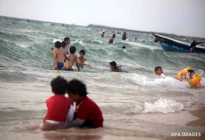 Palestinians enjoy swimming in the sea at Gaza beach during Friday holiday in Gaza city, May 24, 2013. Gazans escape to the beach and out from their homes during heat wave and power outages. Photo by Ashraf Amra