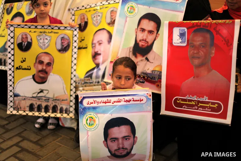 Palestinian children hold pictures of prisoners held in Israeli jails during a protest at inside Red Cross office in Gaza City, on May. 27, 2013 in solidarity with Palestinian prisoners held by Israel to demand their rel...
