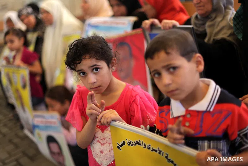 Palestinian children hold pictures of prisoners held in Israeli jails during a protest at inside Red Cross office in Gaza City, on May. 27, 2013 in solidarity with Palestinian prisoners held by Israel to demand their rel...