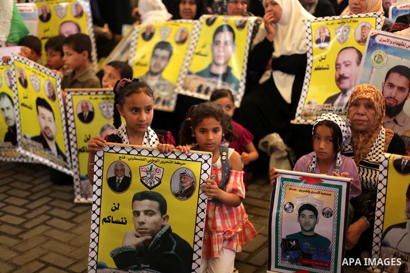 Palestinian children hold pictures of prisoners held in Israeli jails during a protest at inside Red Cross office in Gaza City, on May. 27, 2013 in solidarity with Palestinian prisoners held by Israel to demand their rel...