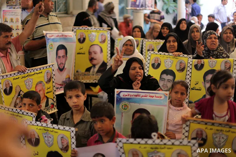 Palestinians hold pictures of prisoners held in Israeli jails during a protest at inside Red Cross office in Gaza City, on May. 27, 2013 in solidarity with Palestinian prisoners held by Israel to demand their release fro...