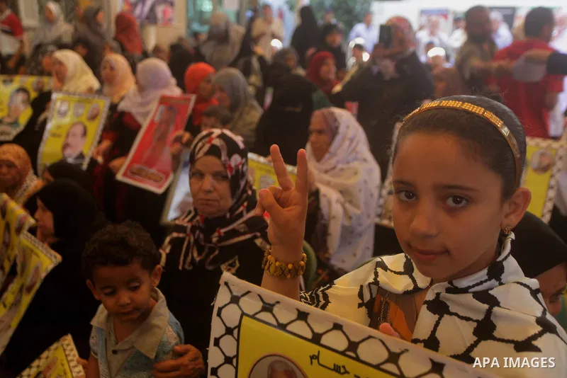 Palestinians hold pictures of prisoners held in Israeli jails during a protest at inside Red Cross office in Gaza City, on May. 27, 2013 in solidarity with Palestinian prisoners held by Israel to demand their release fro...