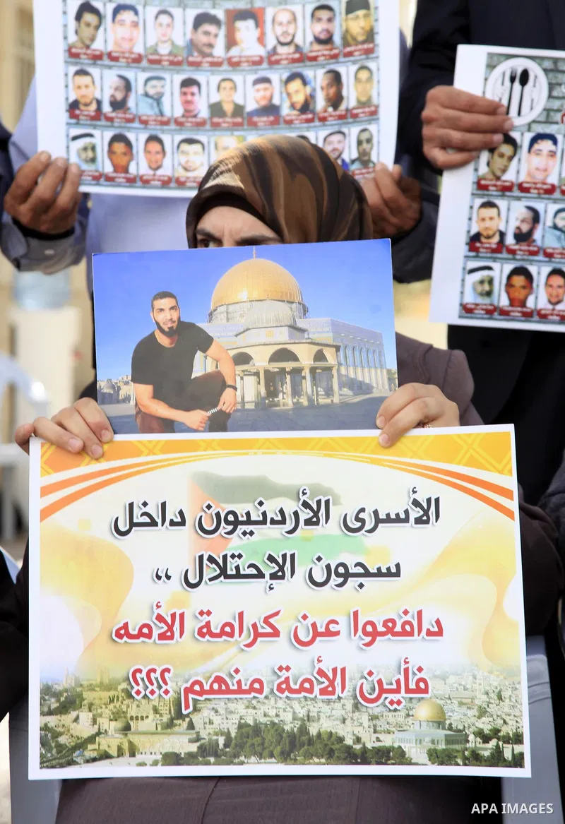 Palestinians hold pictures of Jordanian prisoners held in Israeli jails during a protest in front of Red Cross office in Jerusalem, on May. 30, 2013 in solidarity with Jordanian prisoners on hunger strike. Photo by Saeed...