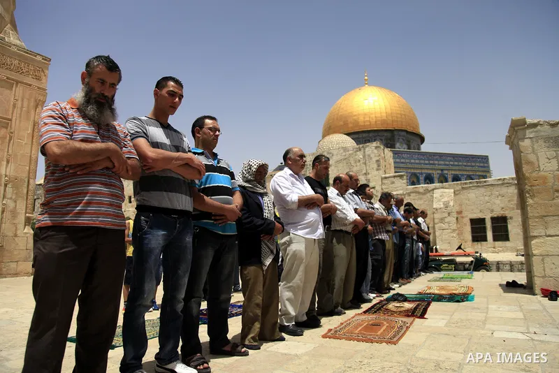 Palestinian worshippers attend Friday prayers at al-Aqsa mosque compound, Islam's third holiest site, in Jerusalem's old city on May 31, 2013, Dome of the Rock mosque in background. Photo by Saeed Qaq