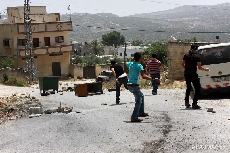 Palestinian protesters throw stones towards Israeli soldiers during clashes following a protest against the expropriation of Palestinian land by Israel on March 31, 2013 in the village of Kfar Qaddum, near the occupied W...