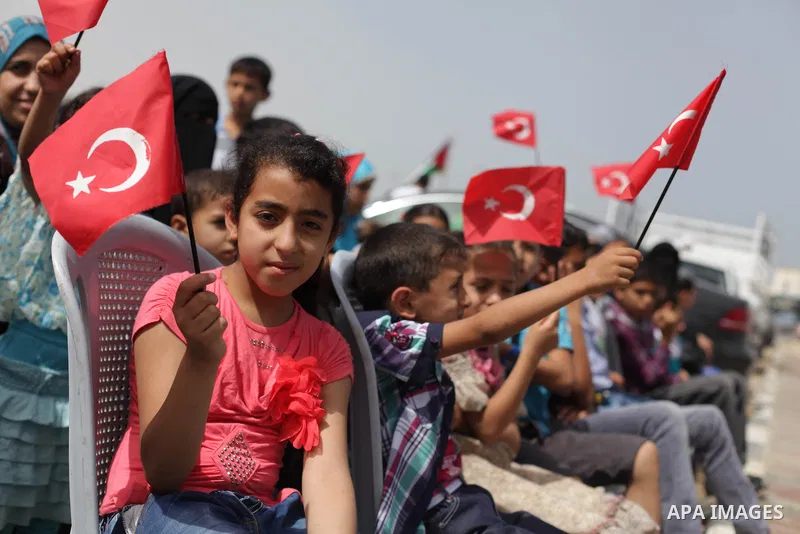 Palestinians hold Turkish flags during a rally marking the third anniversary of attack on the Turkish flotilla Mavi Marmara at Gaza seaport on May 31, 2013. Turkey broke off diplomatic relations with Israel in 2010, afte...