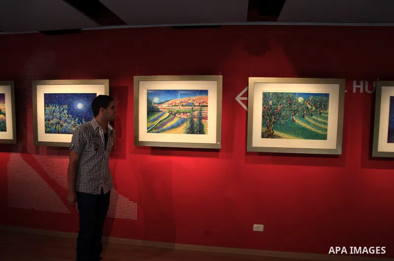 A visitor veiws painting during the art show of Palestinian artist Taleb Dweik titled "Dreams" at Yabous cultural center, in Jerusalem on June 01, 2013. Taleb Dweik is an Jerusalemite artist with a unique style that is q...
