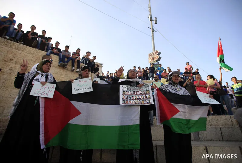 Palestinian protesters hold placards during a demonstration outside the Damascus gate marking the 46th anniversary of the 1967 Middle East war, in Jerusalem's old city June 05, 2013. Israel captured East Jerusalem, the G...