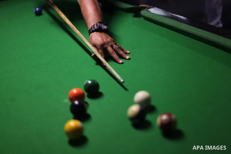 A Palestinian man plays billiard at a games club in Gaza city June 05, 2013. Photo by Ashraf Amra