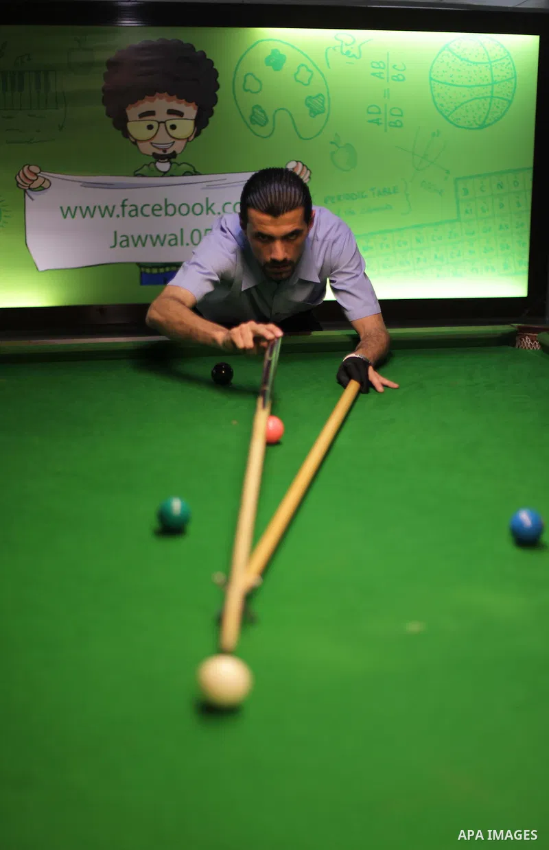 A Palestinian man plays billiard at a games club in Gaza city June 05, 2013. Photo by Ashraf Amra