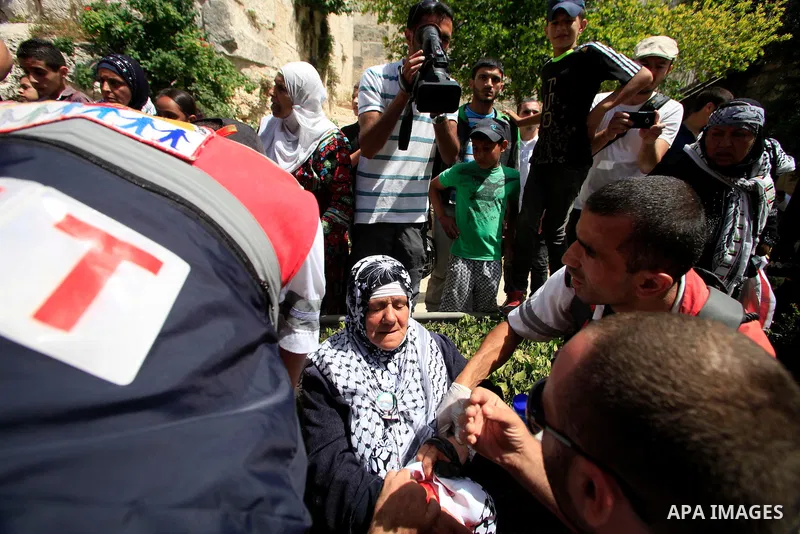 Palestinian medics treat a woman during a demonstration to mark the Naksa (setback) on June 7, 2013 at Damascus Gate in Jerusalem. Palestinians mark "Naksa Day" to mourn the 46th anniversary of Israel's occupation of the...
