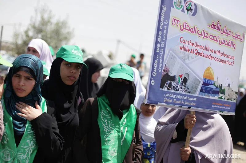 Palestinians gather during a protest near the border between Israel and the northern Gaza Strip June 7, 2013. The protest was part of the Global March to Jerusalem initiative, marking the 46th anniversary of Israel's cap...