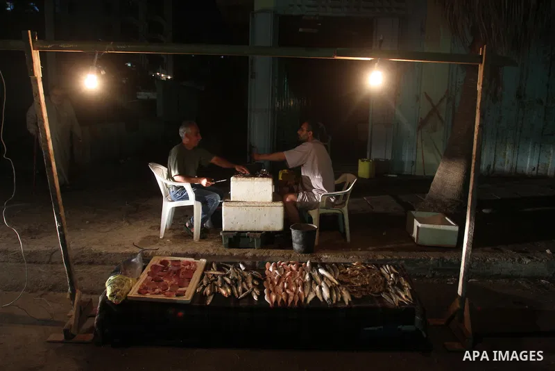 Palestinian fishermen sell fish on the beach front after their return from the sea in Gaza City on June 07, 2013. Photo by Mohammed Asad