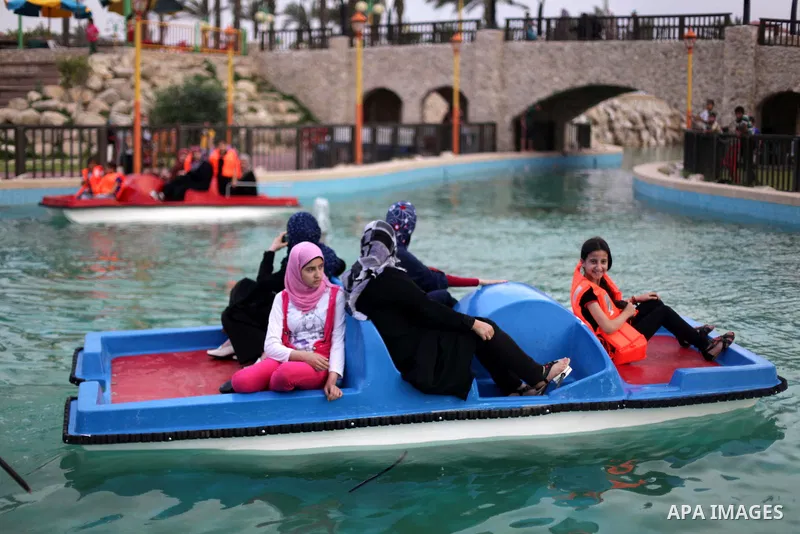 Palestinians ride a boat in a swimming pool at al-Nour resort in Gaza City June 12, 2013. Al-Nour resort was established on the land of former Jewish settlement of Netzarim where it is open for free for the families of P...
