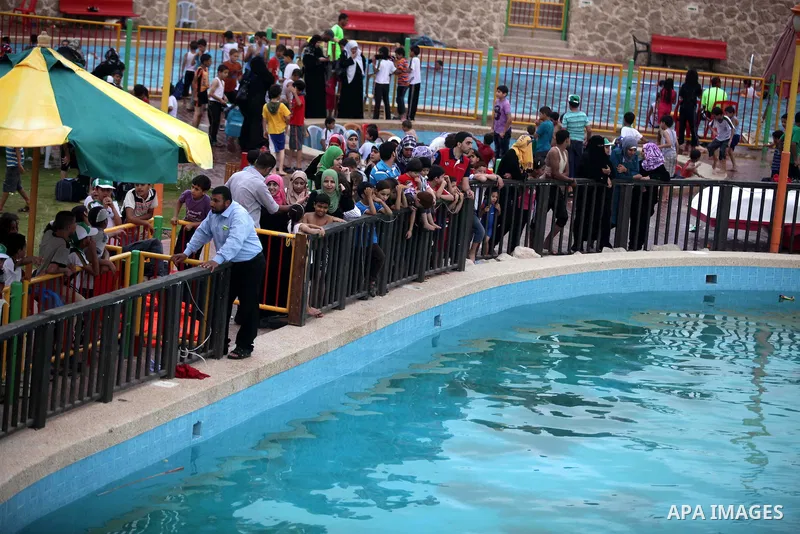 Palestinians ride a boat in a swimming pool at al-Nour resort in Gaza City June 12, 2013. Al-Nour resort was established on the land of former Jewish settlement of Netzarim where it is open for free for the families of P...