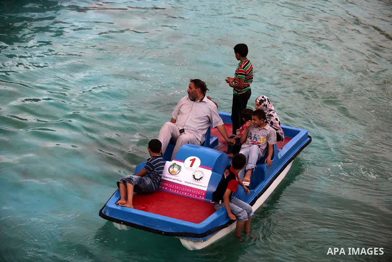 Palestinians ride a boat in a swimming pool at al-Nour resort in Gaza City June 12, 2013. Al-Nour resort was established on the land of former Jewish settlement of Netzarim where it is open for free for the families of P...