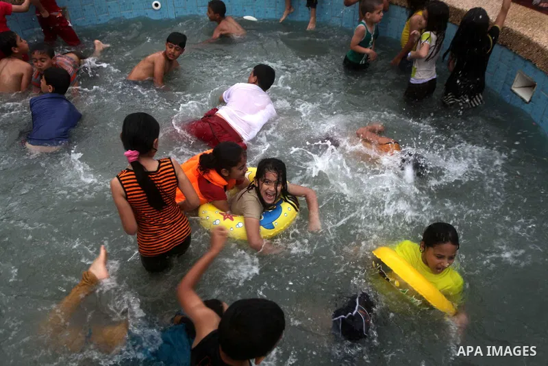 Palestinians play inside a swimming pool at al-Nour resort in Gaza City June 12, 2013. Al-Nour resort was established on the land of former Jewish settlement of Netzarim where it is open for free for the families of Pale...