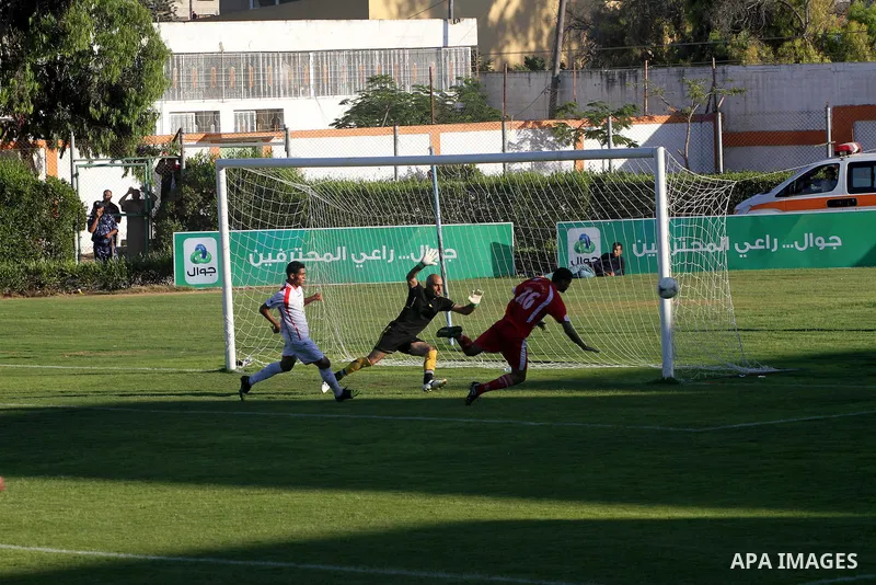 Players from Khan Yunis Youth Club (red) against the Players from Gaza Sports Club team (White), play during a football match in the League Jawwal in Gaza city on June 15, 2013. had completed in this match for Khan Yunis...