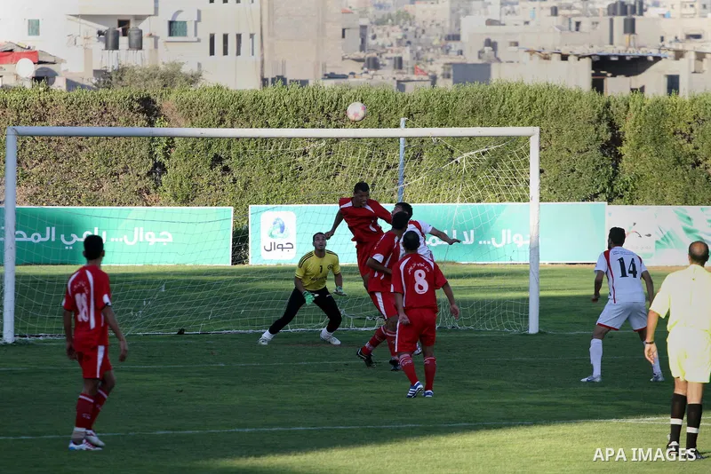 Players from Khan Yunis Youth Club (red) against the Players from Gaza Sports Club team (White), play during a football match in the League Jawwal in Gaza city on June 15, 2013. had completed in this match for Khan Yunis...