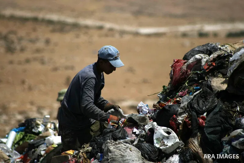 Young Palestinians rummage through a garbage dump on the outskirts of Yatta, south of the West Bank city of Hebron, June 17, 2013. The boys reportedly scrounge through garbage to collect scrap metal and plastic that coul...