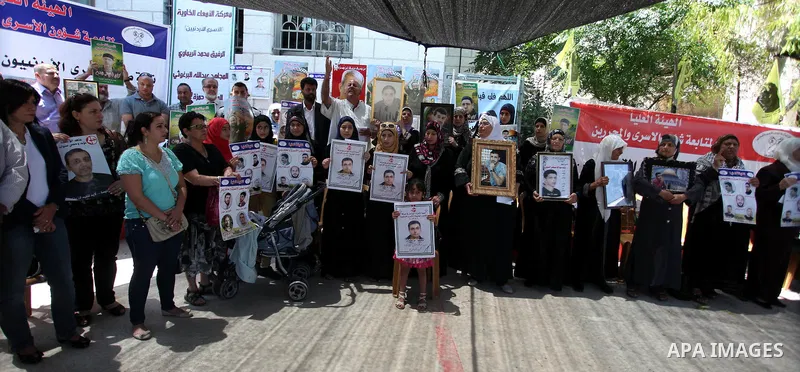 Relative of Jordanian prisoners in held by Israel hold pictures of prisoners who are on hunger strike during a protest in front of the Red Cross headquarter in the West Bank city of Ramallah demanding for their release,...