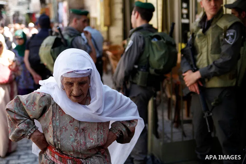 A Palestinian elderly woman walks past Israeli security guards following Friday prayers at al-Aqsa mosque, in Jerusalem's old city on June 21, 2013. A security guard shot and killed a Jewish Israeli man on Friday at one...
