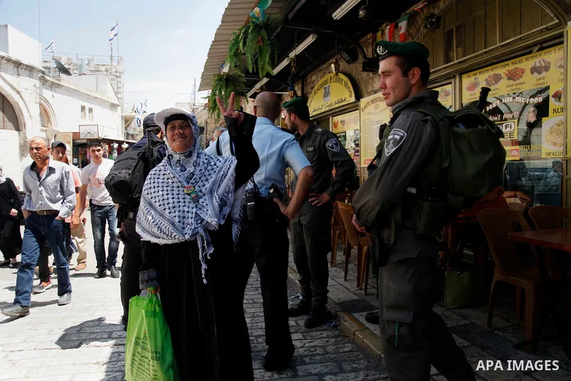 A Palestinian elderly woman walks past Israeli security guards following Friday prayers at al-Aqsa mosque, in Jerusalem's old city on June 21, 2013. A security guard shot and killed a Jewish Israeli man on Friday at one...