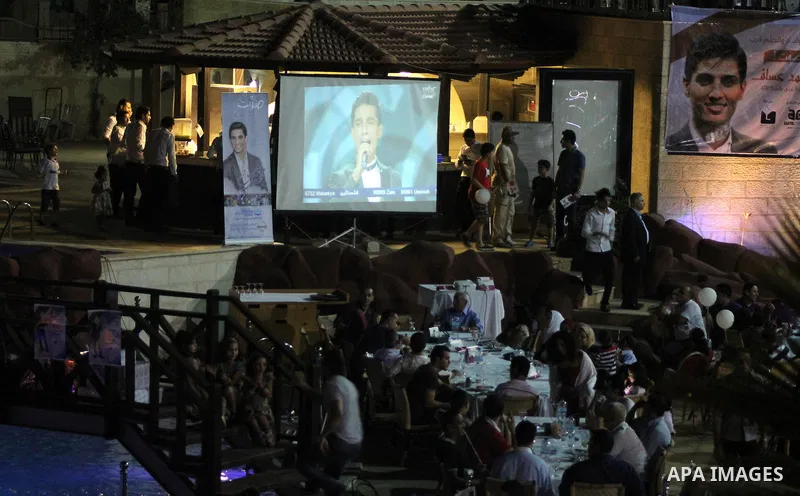 Palestinians watch the televised performance of Mohammad Assaf, 23, a Palestinian finalist on the Arab Idol talent show, in Gaza City, Friday, June 21, 2013. Assaf, Gazan's powerful voice has propelled him to the final a...