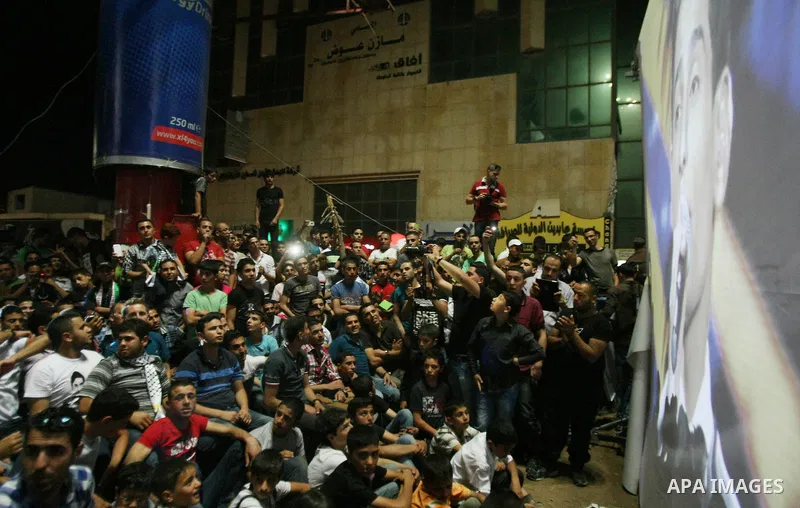 Palestinians celebrate after Palestinian singer Mohammed Assaf won a regional TV singing contest, in the West Bank city of Hebron, Saturday, June 22, 2013. Palestinians relished a rare moment of pride and national unity...