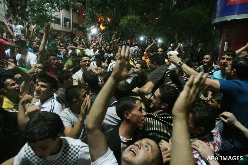 Palestinians celebrate after Palestinian singer Mohammed Assaf won a regional TV singing contest, in the West Bank city of Hebron, Saturday, June 22, 2013. Palestinians relished a rare moment of pride and national unity...