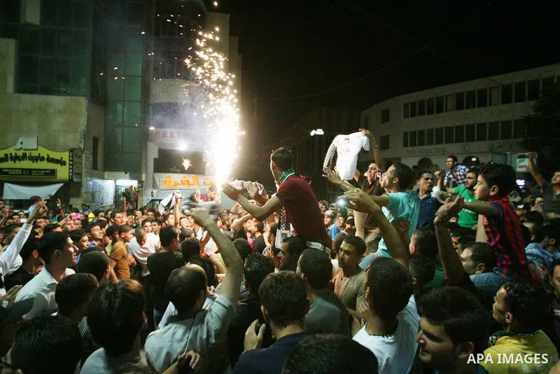 Palestinians celebrate after Palestinian singer Mohammed Assaf won a regional TV singing contest, in the West Bank city of Hebron, Saturday, June 22, 2013. Palestinians relished a rare moment of pride and national unity...