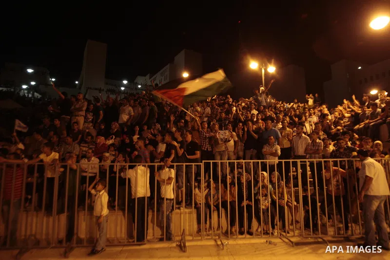 Palestinians celebrate after Palestinian singer Mohammed Assaf won a regional TV singing contest, in the West Bank city of Nablus, Saturday, June 22, 2013. Palestinians relished a rare moment of pride and national unity...