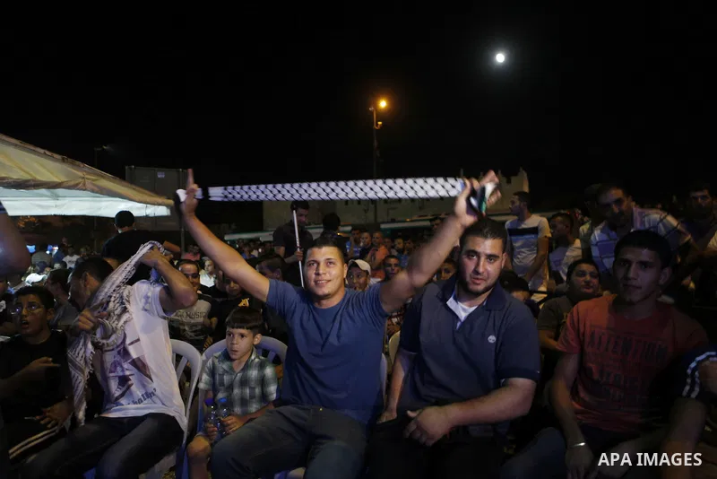 Palestinians celebrate after Palestinian singer Mohammed Assaf won a regional TV singing contest, in Jerusalem, June 22, 2013. Palestinians relished a rare moment of pride and national unity Saturday after the 23-year-ol...