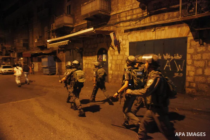 Israeli border police take position after a member of them being struck in the face by an object thrown at him during the arrest of a Palestinian youth near the Damascus Gate entry to the Old City in East Jerusalem on Ju...