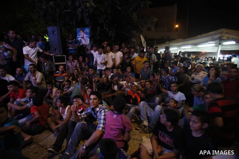 Palestinians celebrate after Palestinian singer Mohammed Assaf won a regional TV singing contest, in Jerusalem, June 22, 2013. Palestinians relished a rare moment of pride and national unity Saturday after the 23-year-ol...