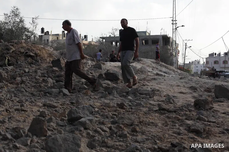 Palestinians survey a site which witnesses said was destroyed in an Israeli air strike in the central Gaza Strip June 24, 2013. Israel carried out air strikes in the Gaza Strip on Monday in response to Palestinian milita...