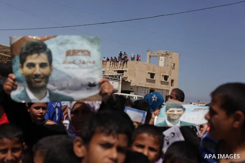 Palestinians wait for the Arab Idol winner Palestinian Mohammed Assaf, unseen, at the entrance of Rafah crossing point on the border between Egypt and southern Gaza Strip, Tuesday, June 25, 2013. Huge crowds of Gazans ga...