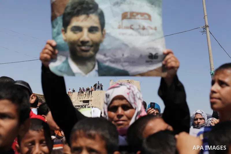 Palestinians wait for the Arab Idol winner Palestinian Mohammed Assaf, unseen, at the entrance of Rafah crossing point on the border between Egypt and southern Gaza Strip, Tuesday, June 25, 2013. Huge crowds of Gazans ga...