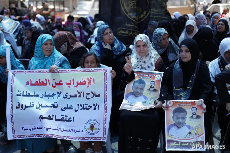 Palestinians hold banners during a protest in front of the Red Cross in Gaza city on June 26, 2013 in solidarity with Palestinian and Jordanians prisoners held by Israel to demand their release from detention without tri...