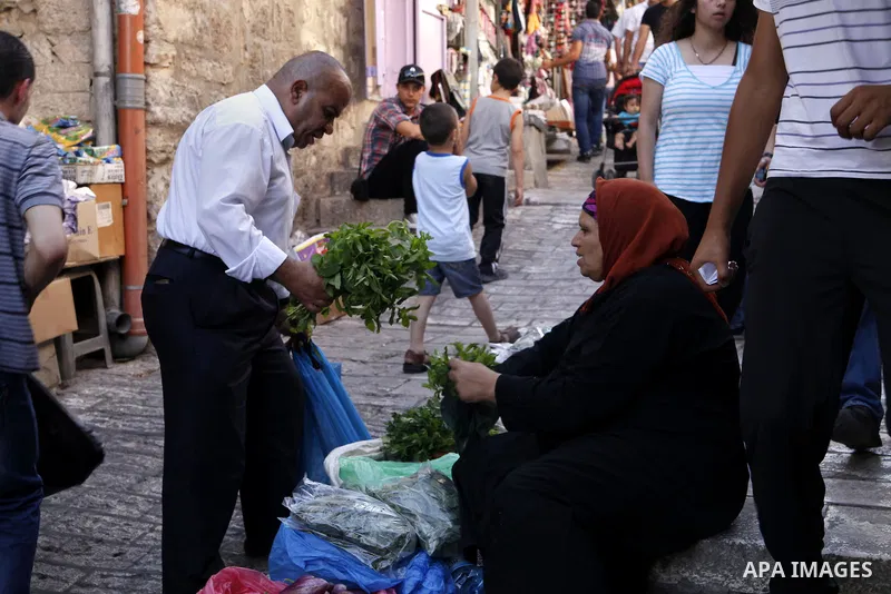 A Palestinian woman sells greens at the market of Damascus gate near al-Aqsa mosque in Jerusalem's Old City, June 26, 2013. Photo by Saeed Qaq