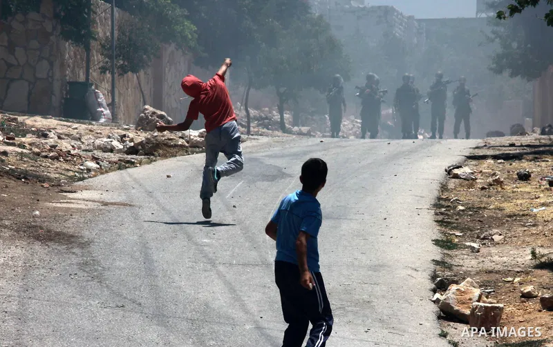 Palestinian protesters throw stones towards Israeli security forces during clashes following a protest against the expropriation of Palestinian land by Israel in the village of Kfar Qaddum near the occupied West Bank cit...