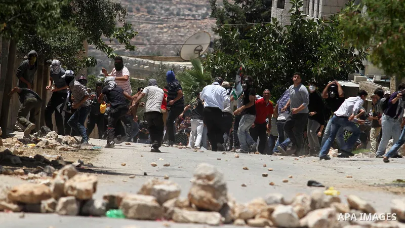 Palestinian protesters throw stones towards Israeli security forces during clashes following a protest against the expropriation of Palestinian land by Israel in the village of Kfar Qaddum near the occupied West Bank cit...