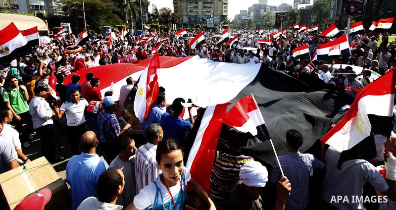 Protesters opposing Egyptian President Mohamed Mursi carry a huge flag as they march to Tahrir square from Mustafa Mahmoud mosque in Cairo June 30, 2013. Mass demonstrations across Egypt on Sunday may determine its futur...