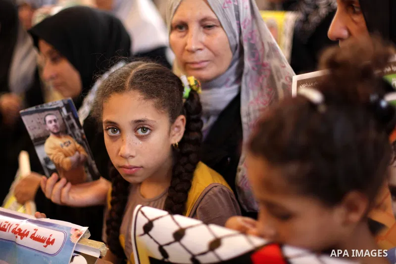 Palestinians hold pictures of prisoners held in Israeli jails during a protest outside Red Cross office in Gaza City, on July 01, 2013 in solidarity with Palestinian prisoners held by Israel to demand their release. Phot...