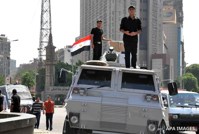 Egyptian police special forces stand on their armored vehicle, protecting a bridge between Tahrir Square and Cairo University, where Muslim Brotherhood supporters have gathered, in Giza, Egypt, Wednesday, July 3, 2013. E...