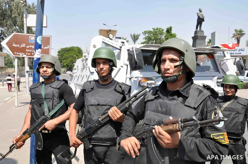 Egyptian police special forces stand next to their armored vehicle, protecting a bridge between Tahrir Square and Cairo University, where Muslim Brotherhood supporters have gathered, in Giza, Egypt, Wednesday, July 3, 20...