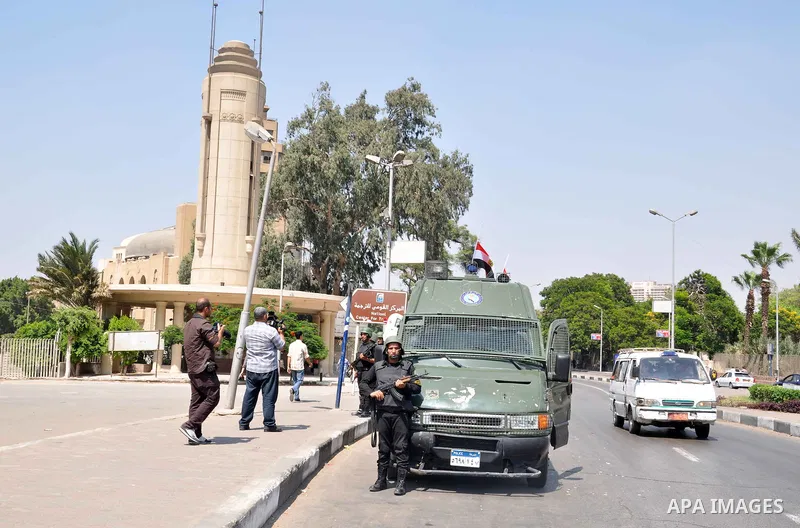 Egyptian police special forces stand next to their armored vehicle, protecting a bridge between Tahrir Square and Cairo University, where Muslim Brotherhood supporters have gathered, in Giza, Egypt, Wednesday, July 3, 20...