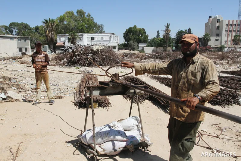 Palestinian laborers adjust used steel bars, at a site of an old prison known as al-Saraya that was destroyed by the Isreali airstrikes during the conflict between Israel and Gaza militants, in Gaza city July 4, 2013. Pa...