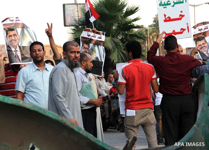 Egyptian supporters of Muslim Brotherhood hold portraits of ousted Egyptian president Mohammed Morsi as they gather at al-Nahda square on July 4, 2013 in Cairo, Egypt. Egypt's army rounded up the leadership of ousted pre...