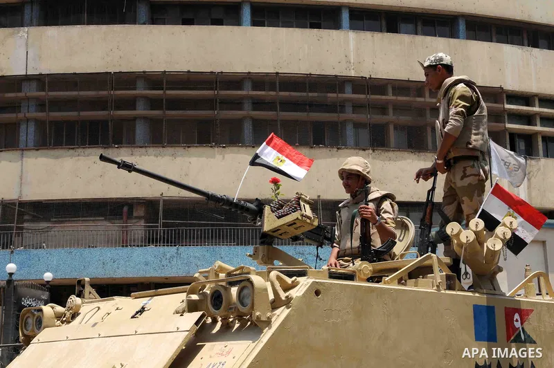 Egyptian military soldiers stand guard atop armored personnel carriers at Maspero, an Egypt's state tv and radio station, not far from Tahrir Square in Cairo Saturday, July 6, 2013. Egyptians were on edge Saturday mornin...